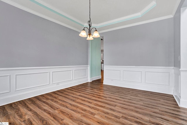 empty room with crown molding, dark wood-type flooring, and an inviting chandelier