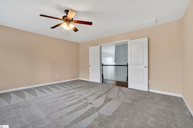 unfurnished room featuring ceiling fan and carpet flooring