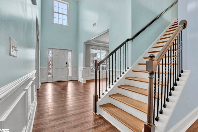 foyer entrance with plenty of natural light, dark hardwood / wood-style floors, and a high ceiling