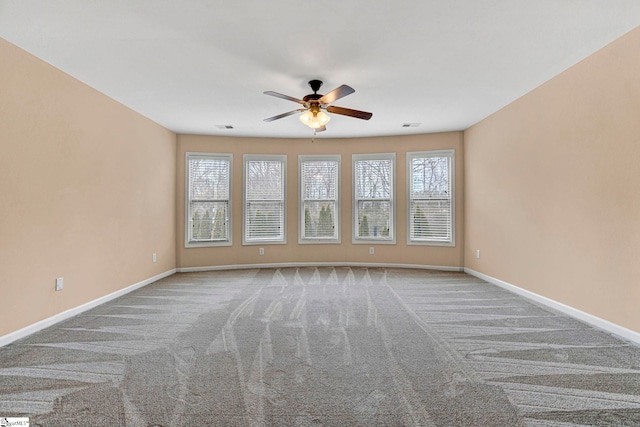 unfurnished room featuring ceiling fan, light colored carpet, and plenty of natural light