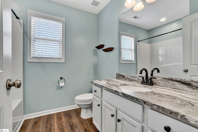 full bathroom with vanity, toilet,  shower combination, and hardwood / wood-style floors