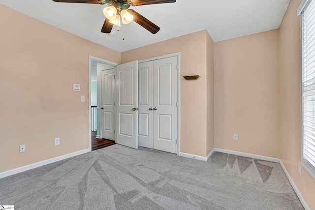 unfurnished bedroom featuring light colored carpet, a closet, and ceiling fan