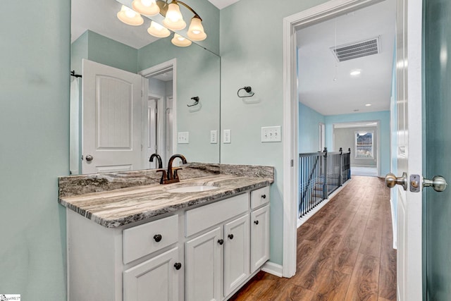 bathroom featuring vanity, hardwood / wood-style floors, and a notable chandelier