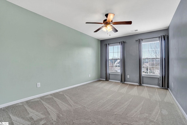 spare room featuring light colored carpet and ceiling fan