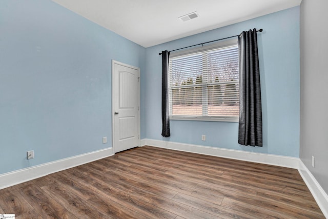 unfurnished room with dark hardwood / wood-style flooring