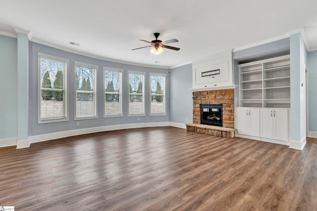 unfurnished living room with ornamental molding, a stone fireplace, and hardwood / wood-style floors