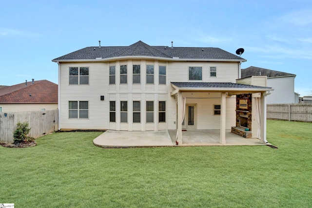 back of house with a lawn, a fireplace, and a patio area