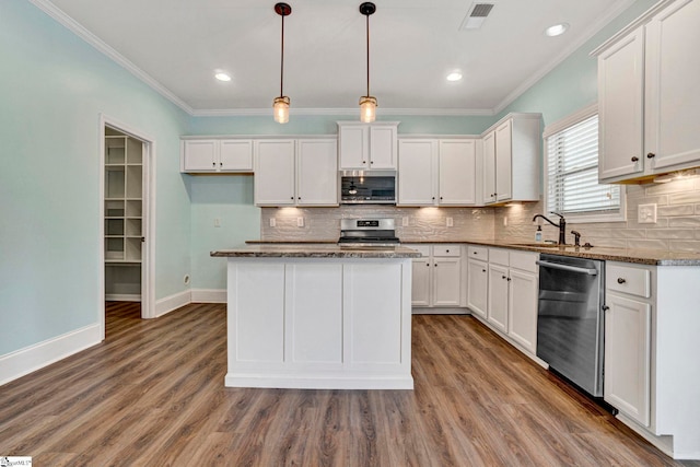 kitchen featuring pendant lighting, sink, appliances with stainless steel finishes, a center island, and white cabinets