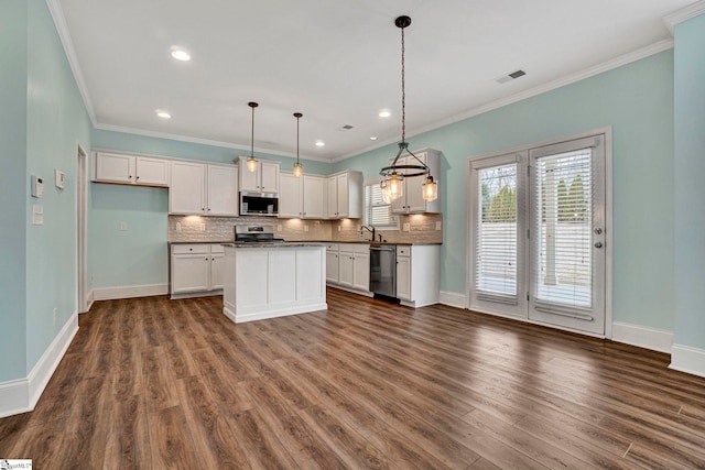 kitchen featuring stainless steel appliances, a center island, white cabinets, and decorative light fixtures