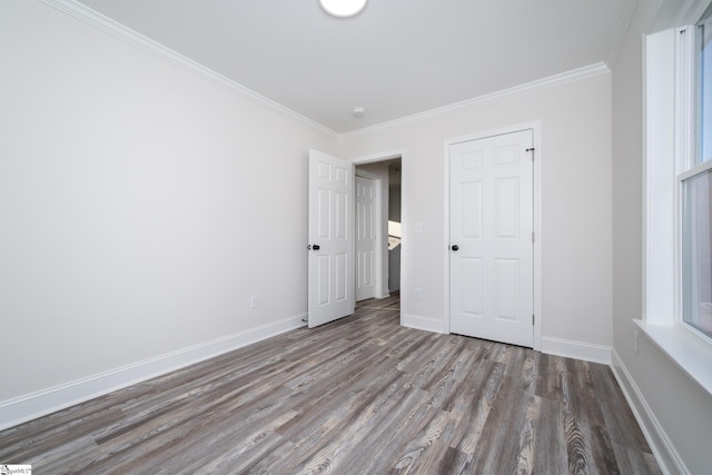 unfurnished bedroom with crown molding and hardwood / wood-style flooring