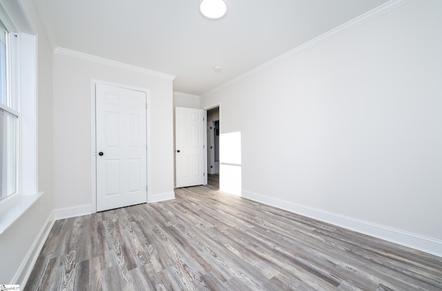 unfurnished bedroom featuring crown molding and light hardwood / wood-style flooring