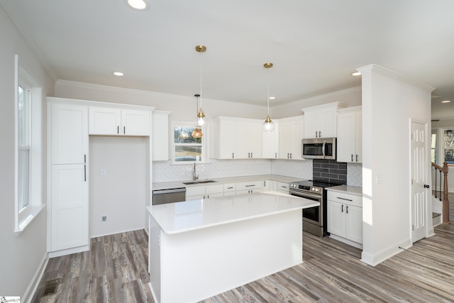 kitchen with a kitchen island, white cabinetry, appliances with stainless steel finishes, and sink