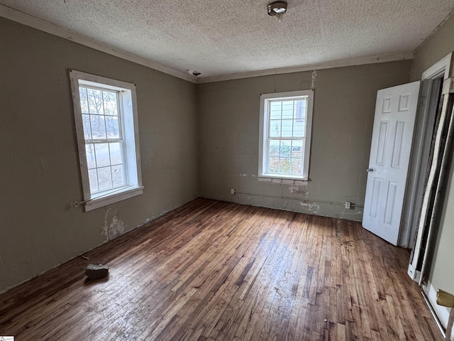 unfurnished bedroom featuring ornamental molding, wood-type flooring, and a textured ceiling