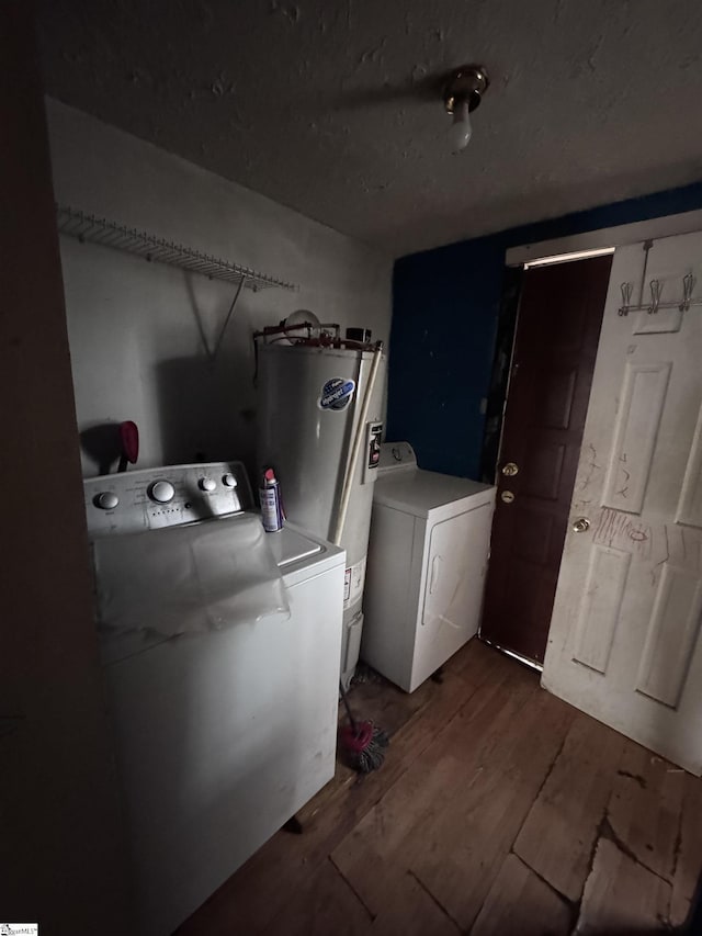 laundry room with water heater, washing machine and clothes dryer, and dark hardwood / wood-style flooring