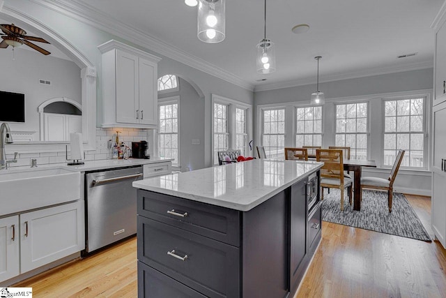 kitchen with a kitchen island, appliances with stainless steel finishes, decorative light fixtures, sink, and white cabinets