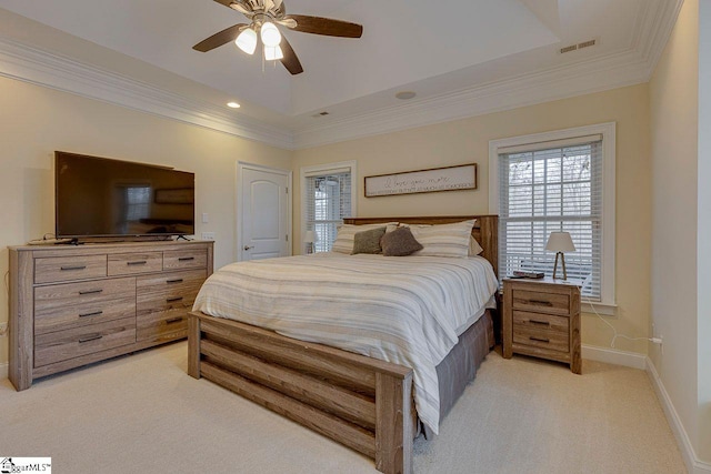 carpeted bedroom with ceiling fan, ornamental molding, and a raised ceiling