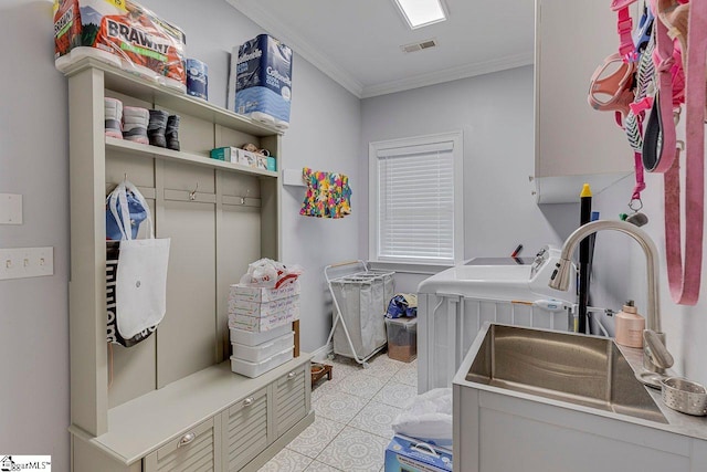 laundry area featuring sink, ornamental molding, and washing machine and clothes dryer