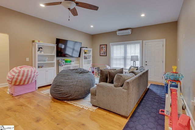 living room featuring an AC wall unit, hardwood / wood-style floors, and ceiling fan