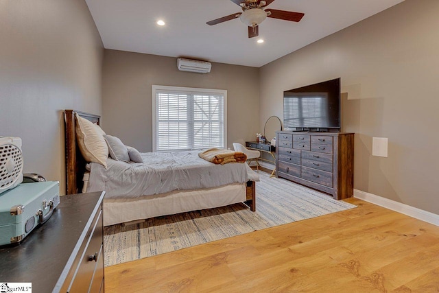 bedroom with ceiling fan, a wall mounted air conditioner, and hardwood / wood-style floors