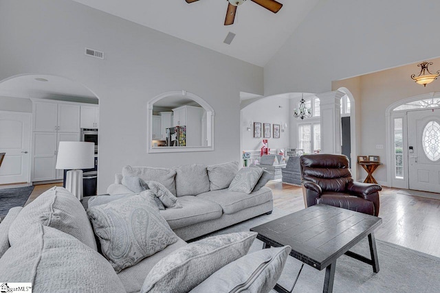 living room featuring high vaulted ceiling, plenty of natural light, and light hardwood / wood-style floors