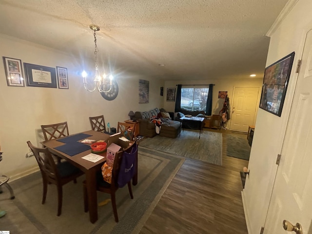 dining area featuring a notable chandelier, dark wood finished floors, ornamental molding, a textured ceiling, and baseboards