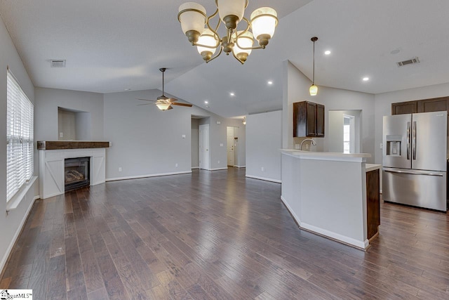 kitchen featuring stainless steel refrigerator with ice dispenser, dark wood-type flooring, sink, vaulted ceiling, and ceiling fan with notable chandelier