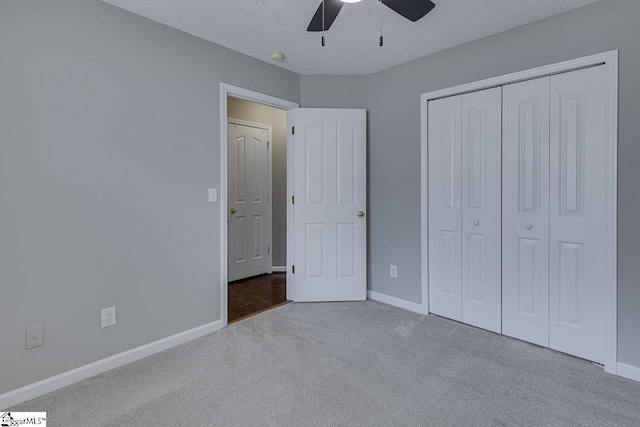 unfurnished bedroom featuring light carpet, a textured ceiling, ceiling fan, and a closet