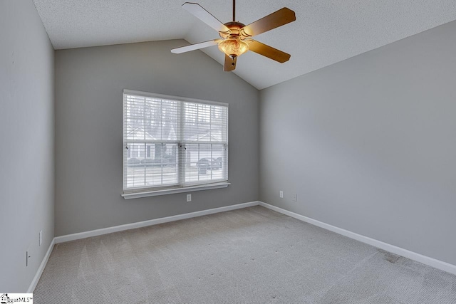 carpeted spare room featuring a textured ceiling, vaulted ceiling, and ceiling fan