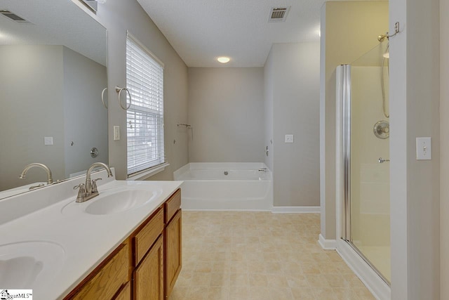 bathroom featuring vanity, plus walk in shower, and a textured ceiling