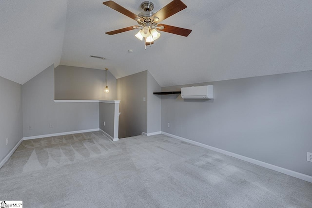 bonus room with an AC wall unit, lofted ceiling, ceiling fan, light carpet, and a textured ceiling