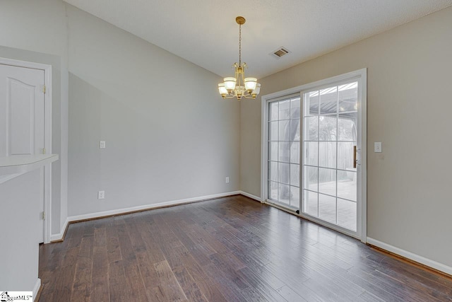 unfurnished room with an inviting chandelier and dark wood-type flooring