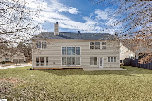 back of house featuring a lawn and a patio