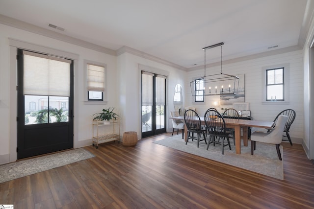 dining space featuring ornamental molding, dark hardwood / wood-style floors, and a chandelier