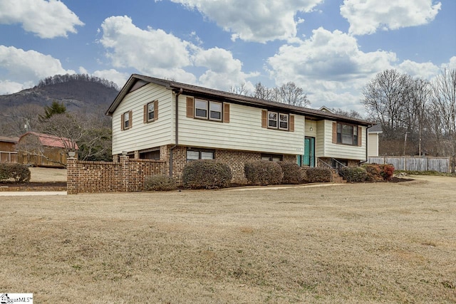 raised ranch featuring a mountain view and a front yard