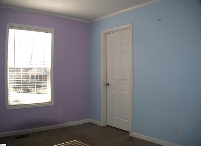 empty room with dark colored carpet and crown molding