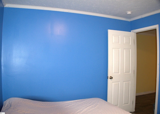 unfurnished bedroom with crown molding, hardwood / wood-style floors, and a textured ceiling