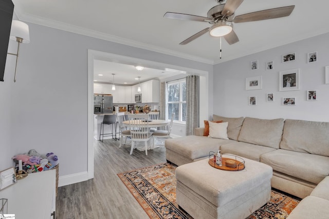 living room featuring ornamental molding, ceiling fan, and light hardwood / wood-style floors