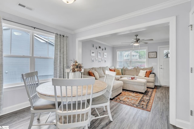 dining space with ornamental molding, dark hardwood / wood-style floors, and ceiling fan