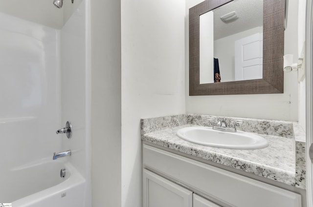 bathroom featuring bathing tub / shower combination, vanity, and a textured ceiling