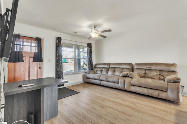 living room with a healthy amount of sunlight, a textured ceiling, and light hardwood / wood-style flooring