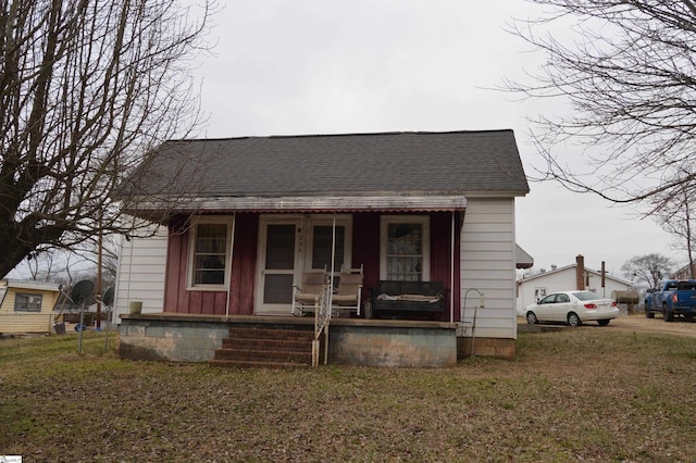 bungalow with a front yard and covered porch