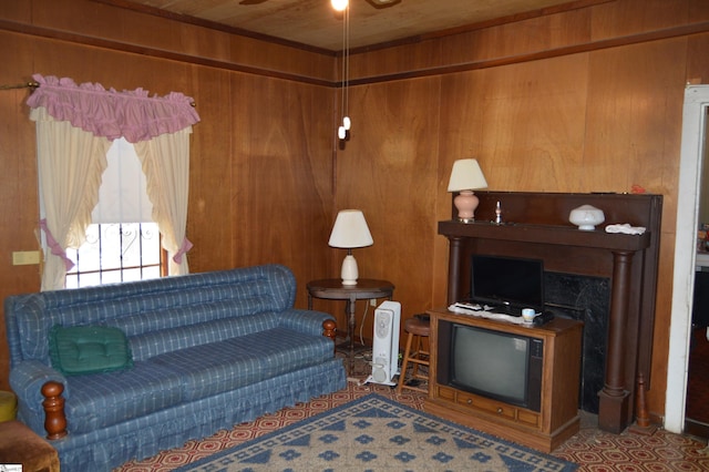 living room featuring wood ceiling, ceiling fan, and wood walls