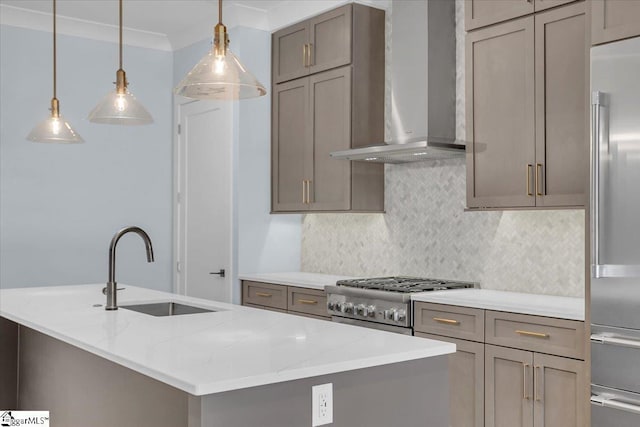 kitchen featuring appliances with stainless steel finishes, sink, a kitchen island with sink, light stone counters, and wall chimney exhaust hood