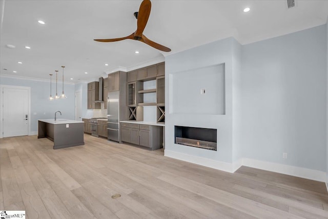 unfurnished living room with sink, light hardwood / wood-style flooring, ornamental molding, and ceiling fan