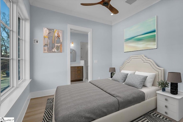 bedroom featuring crown molding, connected bathroom, and light hardwood / wood-style flooring