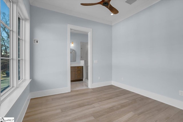 spare room featuring crown molding, ceiling fan, plenty of natural light, and light wood-type flooring