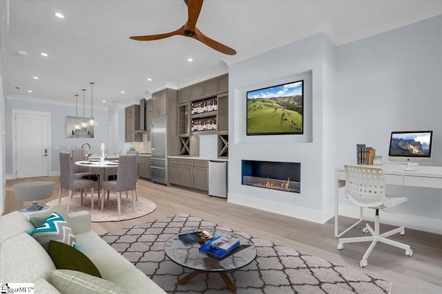 living room with crown molding, built in features, light hardwood / wood-style floors, and ceiling fan