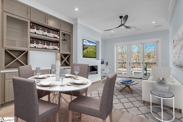 dining room featuring crown molding, light hardwood / wood-style flooring, and ceiling fan