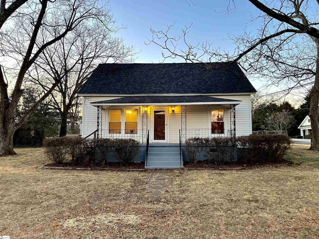 bungalow-style home featuring a porch and a front lawn