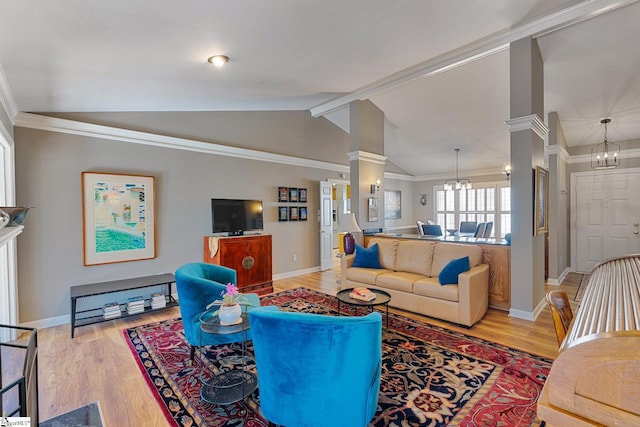 living room with lofted ceiling, a chandelier, light hardwood / wood-style flooring, and ornate columns